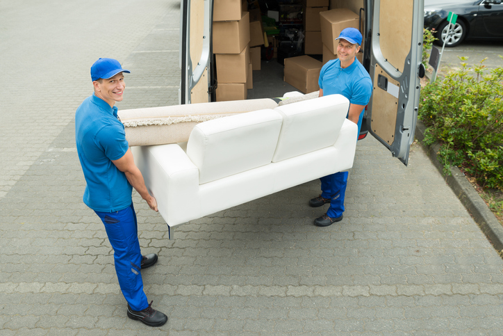 Workers Putting Furniture And Boxes In Truck