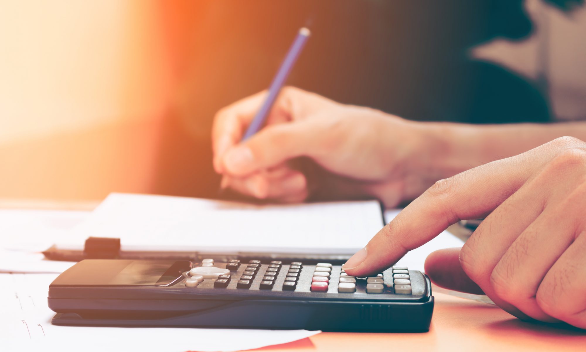 Close up young woman with calculator counting making notes