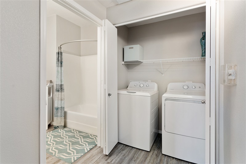 Washer and dryer beside the bathroom at The Cove Apartments.