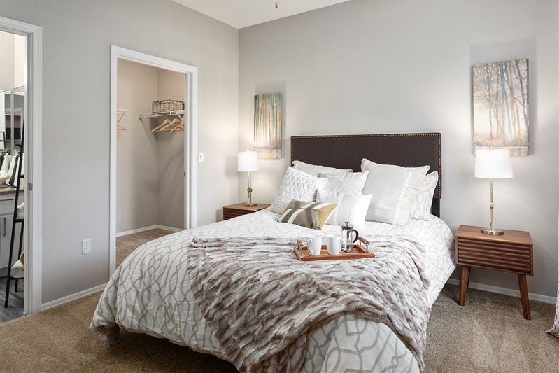 Furnished bedroom shown — representative home at The Cove Apartments.